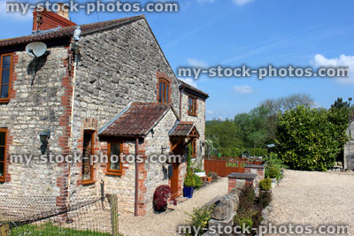 Stock image of traditional English cottage with stone walls, porch and country garden