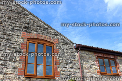 Stock image of extended traditional English stone cottage windows and roof with sky