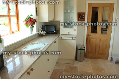 Stock image of country kitchen with pine door, Shaker cabinets, granite worktop, tiles