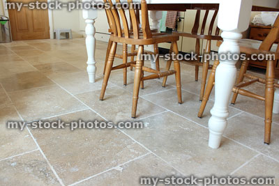 Stock image of filled travertine tile floor, kitchen table and chairs
