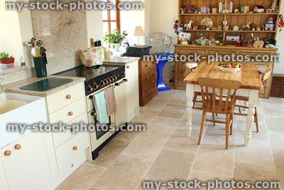Stock image of country kitchen diner, table and chairs, pine dresser, range gas cooker