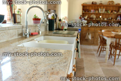 Stock image of country kitchen diner with light granite worktop, double Belfast sink