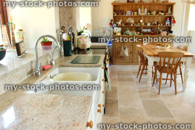 Stock image of country kitchen diner, granite worktop, double Belfast sink, pine dresser