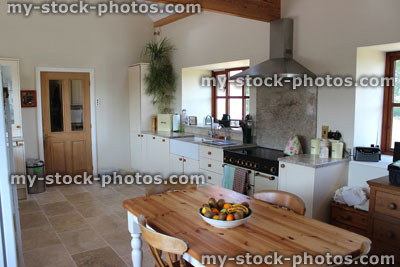 Stock image of country kitchen, granite worktop, gas range cooker, tiled floor, pine table