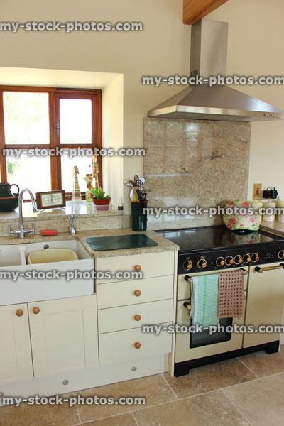 Stock image of country kitchen, cream Shaker doors, double Belfast sink, gas range cooker