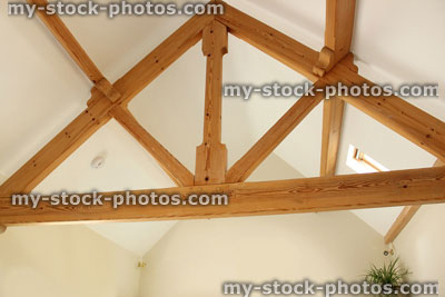Stock image of light oak ceiling beams in modern open plan house, kitchen room