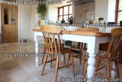 Stock image of painted pine table and chairs, kitchen diner, travertine tile floor
