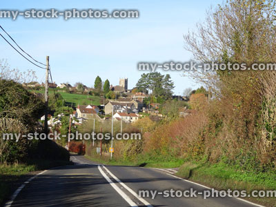 Stock image of country tarmac road, village houses, road markings, solid double centre white lines
