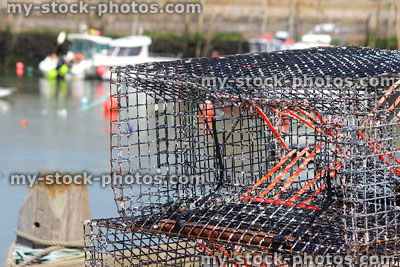Stock image of black mesh lobster pots piled up at fishing harbour