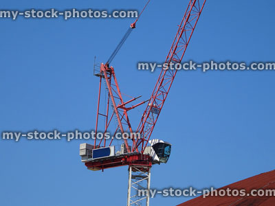 Stock image of red tower crane moving heavy objects on building site