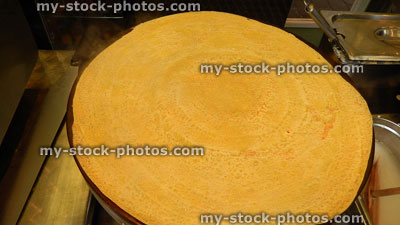 Stock image of crepe pancake being cooked on stove, crepe batter