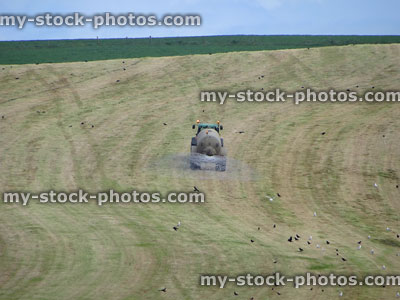 Stock image of farmer in tractor cropping spraying field with chemicals