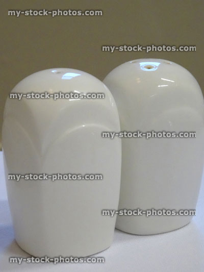 Stock image of white china, square salt and pepper pots, cruet set