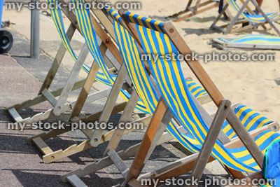 Stock image of row of beach deckchairs on beachfront promenade, English summer holiday