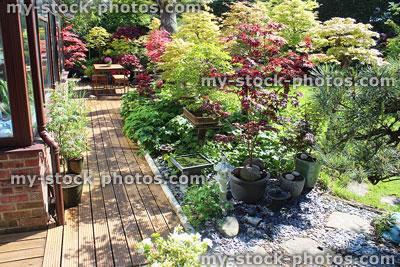 Stock image of sunny south facing back yard, wooden garden furniture, decking