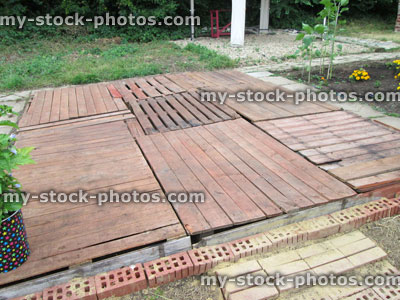 Stock image of cheap decking in garden, made from wooden pallets