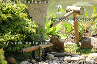 Stock image of bamboo deer scarer, Japanese garden water feature, pebbles