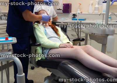Stock image of young girl in dentist chair, toothache, teeth, dental appointment