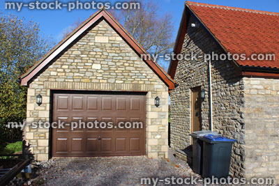 Stock image of detached garage, up and over garage door, bungalow back door, wheelie bins