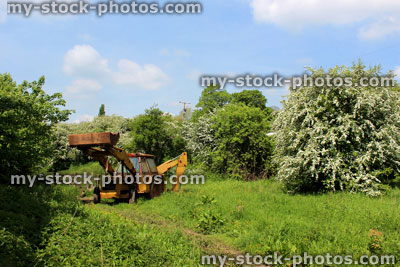 Stock image of rusty old yellow digger in countryside farm field