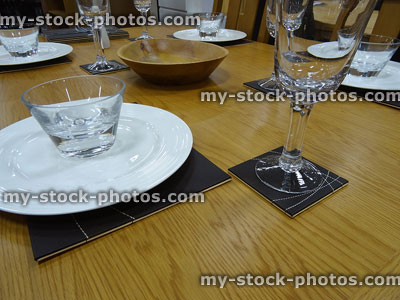 Stock image of dining table laid with dinner plates, placemats, wine glasses