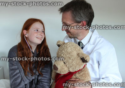 Stock image of fun doctor and girl patient, with teddy bear and stethoscope