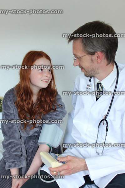 Stock image of doctor checking blood pressure of girl in hospital