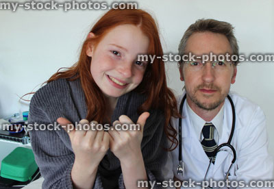 Stock image of happy girl with hospital doctor putting thumbs up