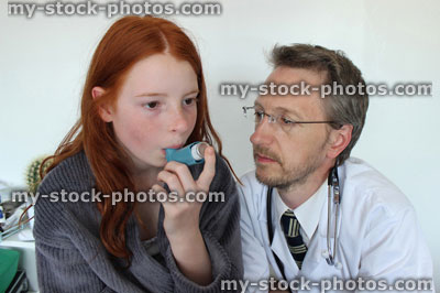 Stock image of hospital doctor showing young girl how to use salbutamol inhaler