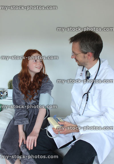 Stock image of doctor checking blood pressure of girl in hospital