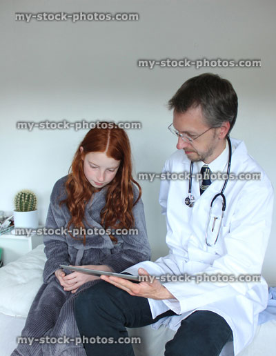 Stock image of hospital doctor showing girl results on tablet computer digital screen