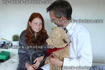 Stock image of fun doctor and girl patient, with teddy bear and stethoscope