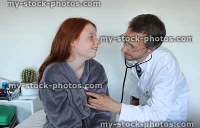 Stock image of hospital doctor with stethoscope, listening to heartbeat of girl patient