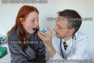 Stock image of hospital doctor showing young girl how to use salbutamol inhaler