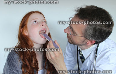 Stock image of hospital doctor looking at girl patient's sore throat