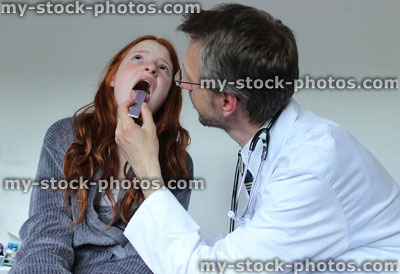 Stock image of hospital doctor looking at girl patient's sore throat