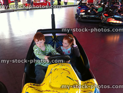 Stock image of children riding on fairground dodgems / bumper cars, funfair