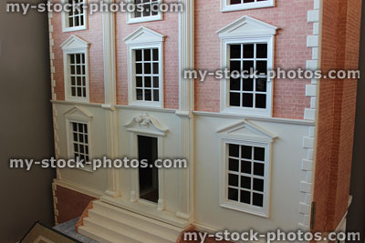 Stock image of large Georgian style dollshouse with brick exterior, painted windows