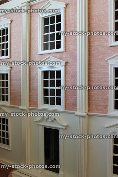 Stock image of front exterior of homemade toy dollshouse, red bricks, window panes
