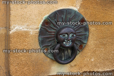 Stock image of ornamental sunshine door knocker on Bathstone wall, by front door