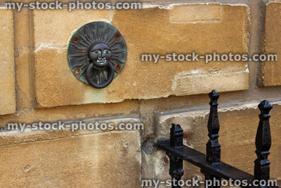 Stock image of ornamental sunshine door knocker on brick wall, by front door