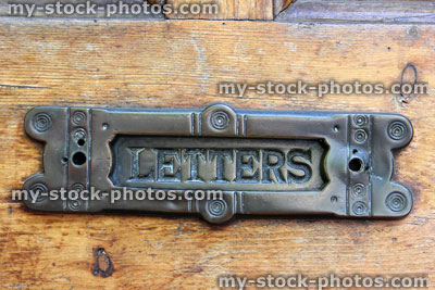 Stock image of old copper letterbox saying 'Letters' on varnished wooden front door