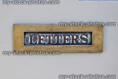 Stock image of brass letterbox saying 'Letters' on white front door
