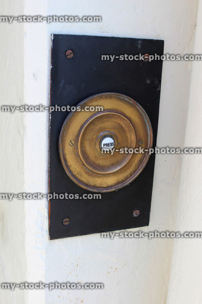 Stock image of ornate, historic brass doorbell next to front door