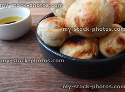Stock image of small, freshly baked dough balls on wooden board, olive oil, balsamic vinegar dip