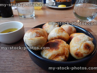 Stock image of small, freshly baked dough balls on wooden board, olive oil, balsamic vinegar dip