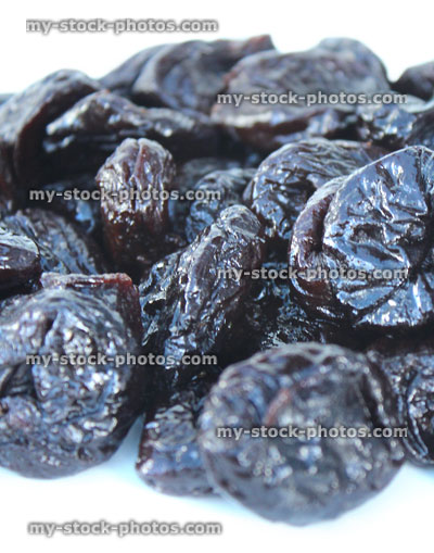 Stock image of pile of dried prunes / stoned fruit, healthy food, white background