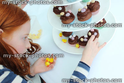 Stock image of girl displaying Easter cakes on cake stand