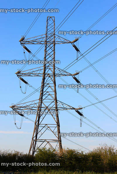 Stock image of large high voltage electricity pylon against blue sky