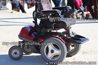 Stock image of empty, modern electric powered wheelchair seat on pavement